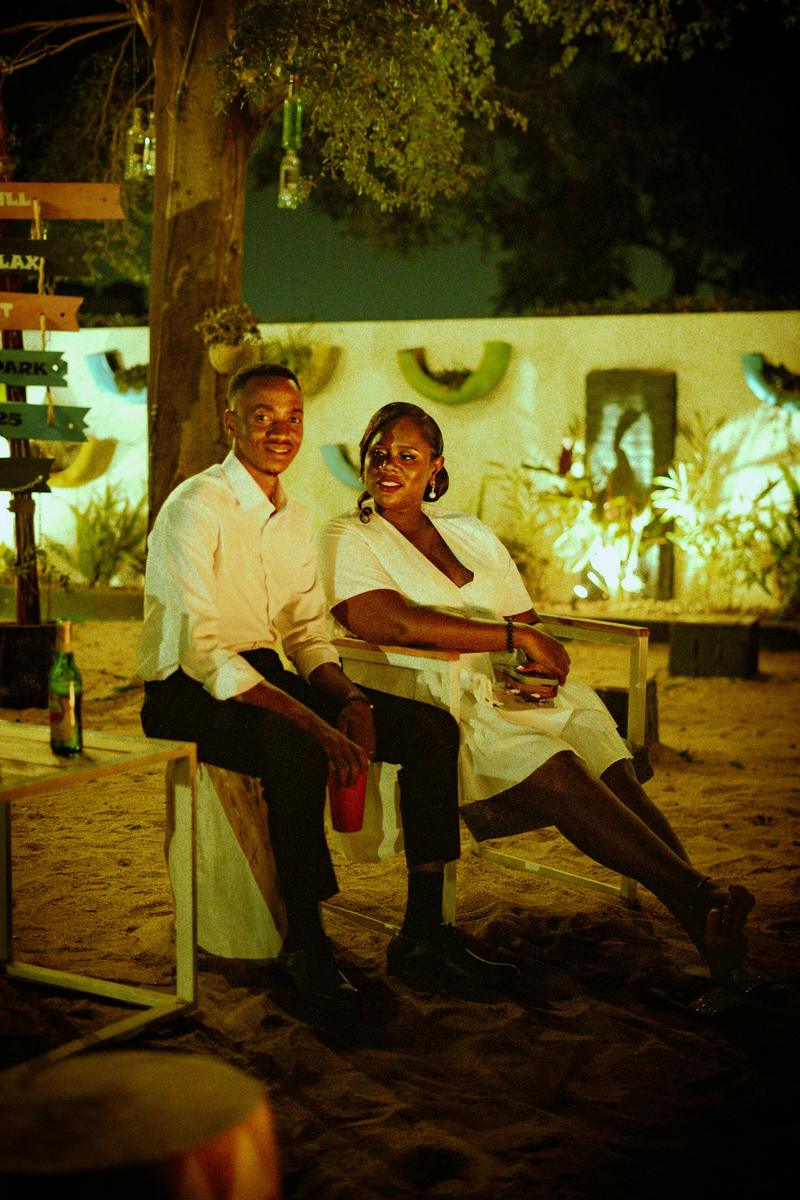 Un couple souriant assis dehors le soir