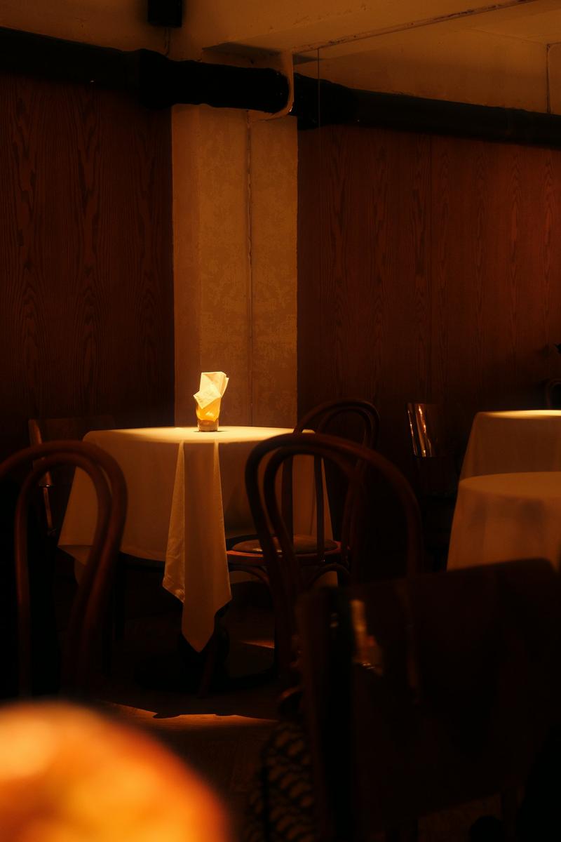 Une table pour deux éclairée par une seule bougie dans une salle tamisée